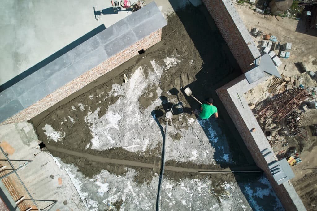 aerial view of man builder shoveling sand cement m 2026 01 07 01 02 48 utc