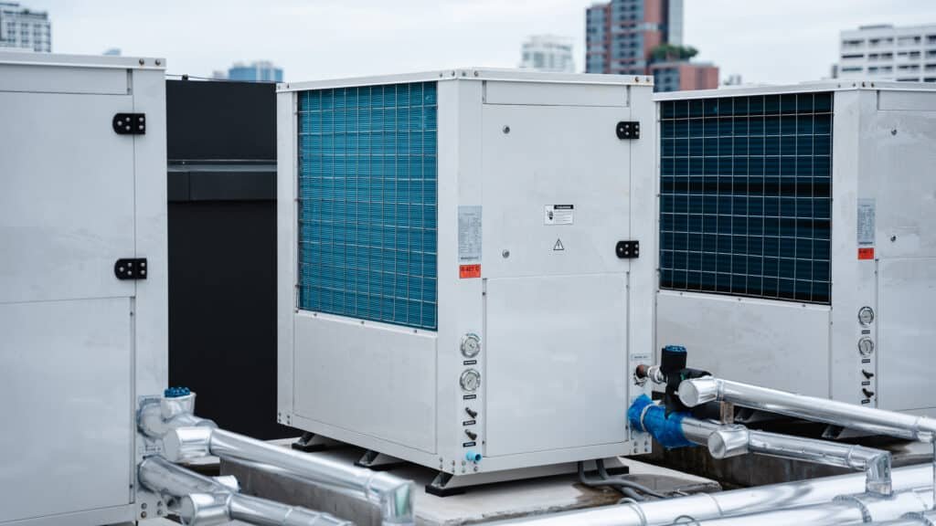 air conditioner compressor installed on the roof of a building, along with industrial air conditioning units and ventilation systems.
