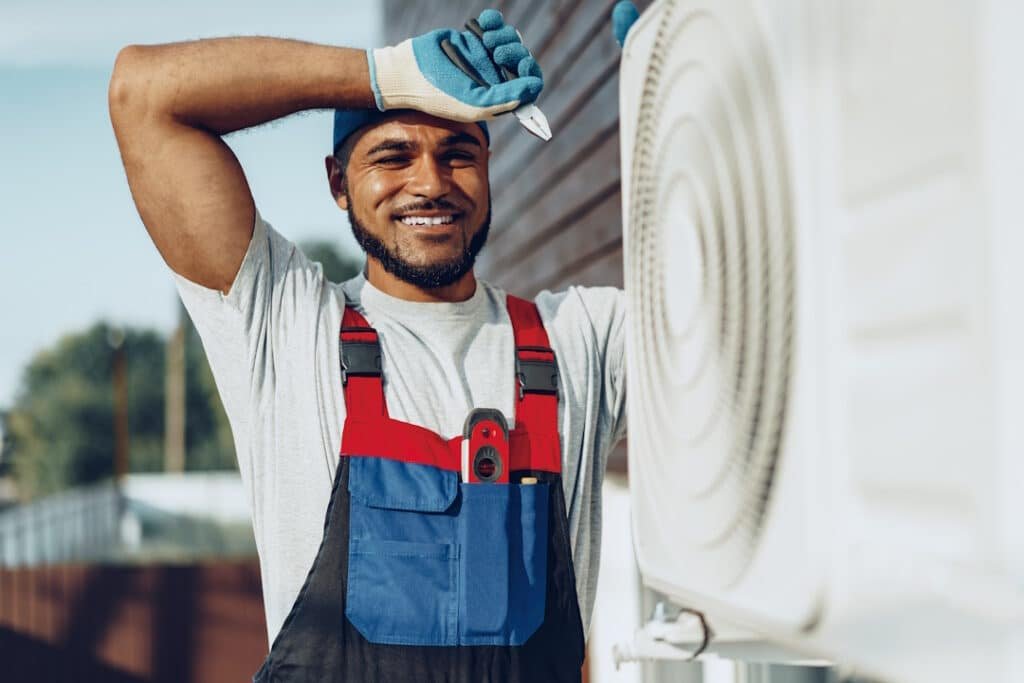 young black man repairman checking an outside air conditioner unit close up