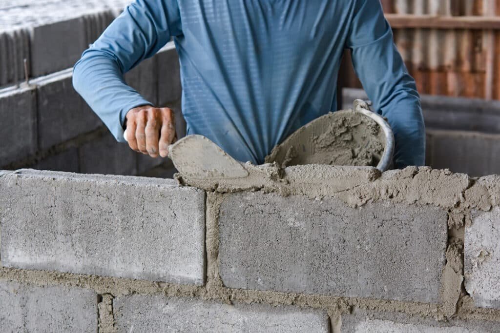 bricklayer laying bricks on mortar