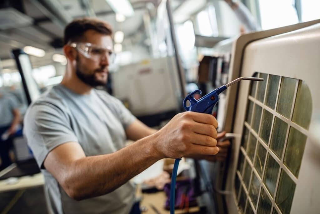 close up of worker operating an industrial machine in a factory.