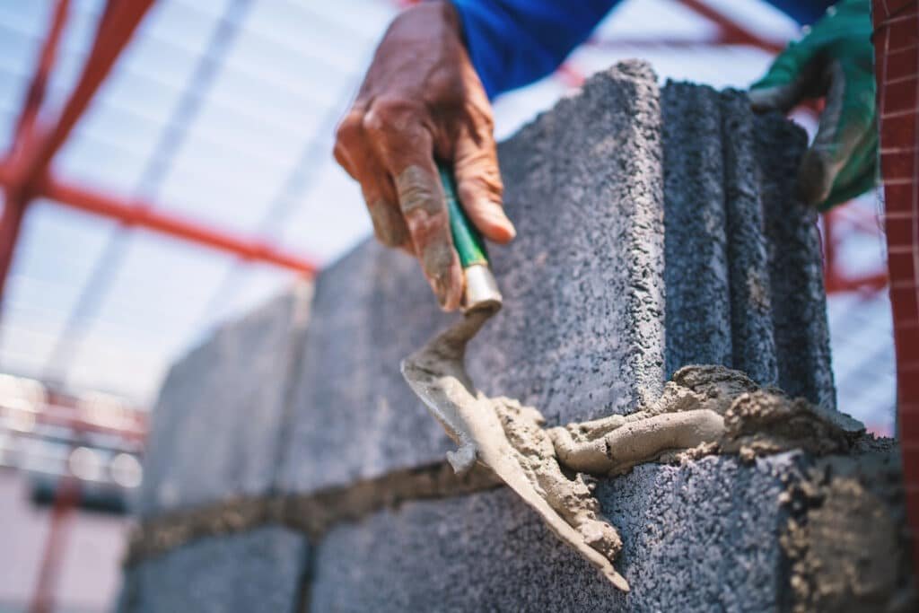 construction worker applies mortar on concrete blo 2026 03 27 00 49 10 utc