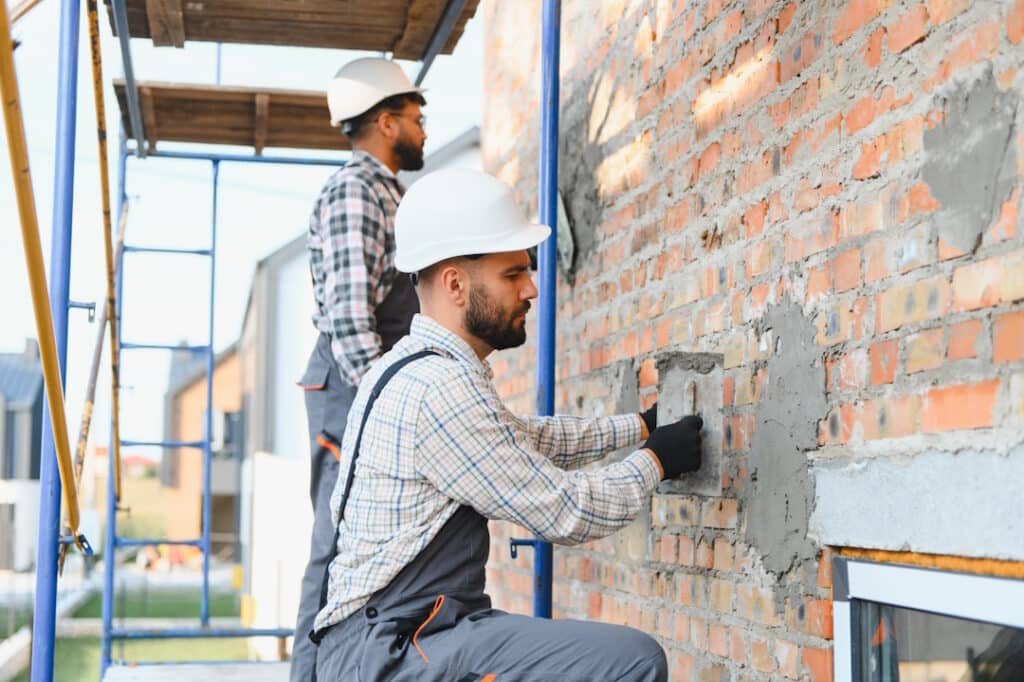 construction workers plastering brick wall on buil 2026 03 26 23 12 06 utc