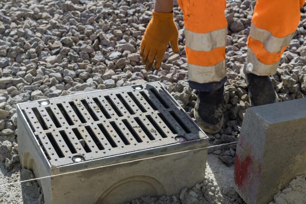 grate on well concrete base during the laying water drainage construction