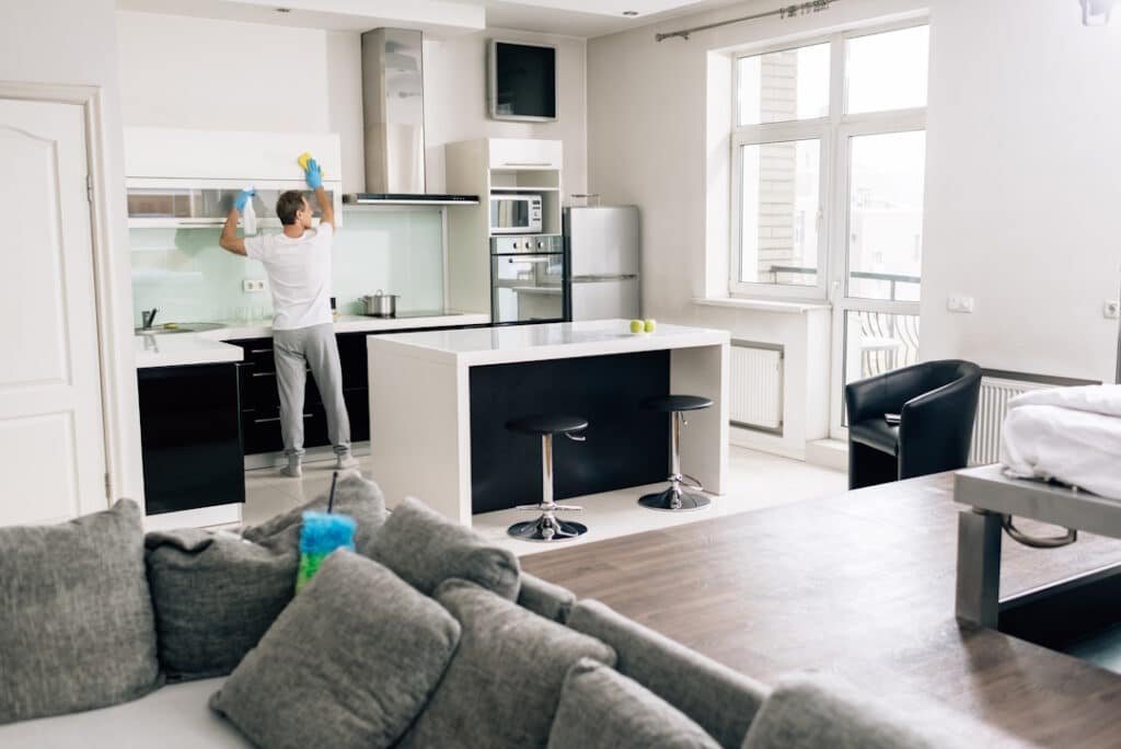 selective focus of man cleaning kitchen at modern home