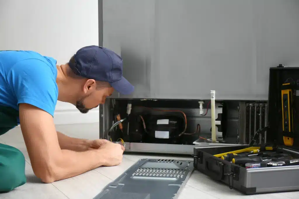 repairman fixing refrigerator appliance with tools 2026 03 26 23 50 08 utc