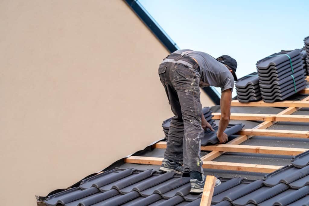 roofer installing tiles on a building s roof 2026 03 17 17 46 43 utc