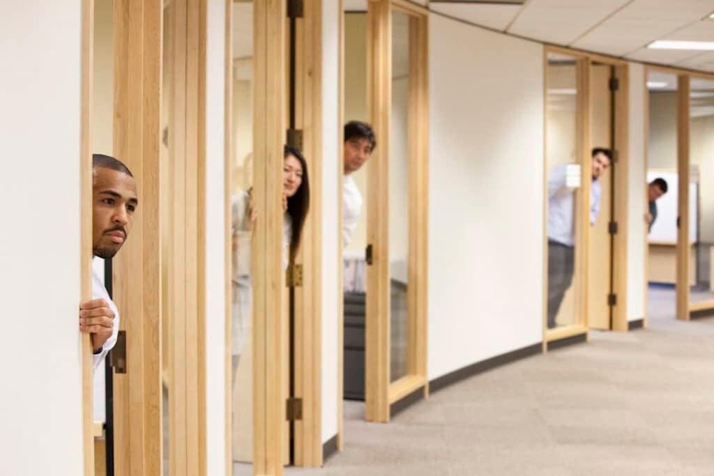 individual business people looking out the doorway of their offices.