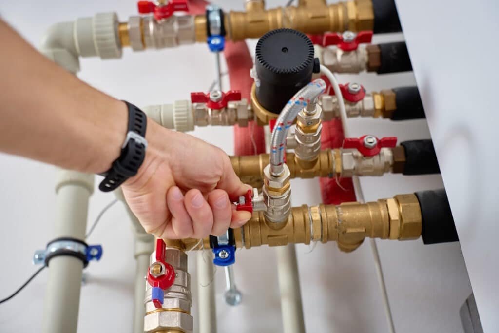 technician adjusting valve on heat pump piping sys 2026 03 27 00 44 51 utc