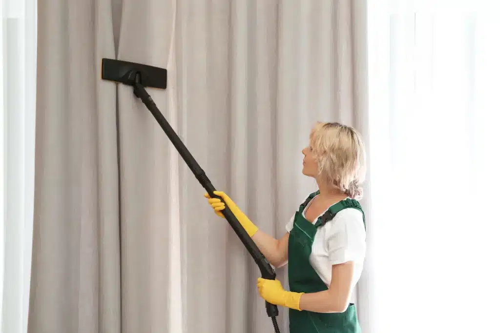 woman cleaning curtains with steam cleaner indoors 2026 03 27 02 22 24 utc