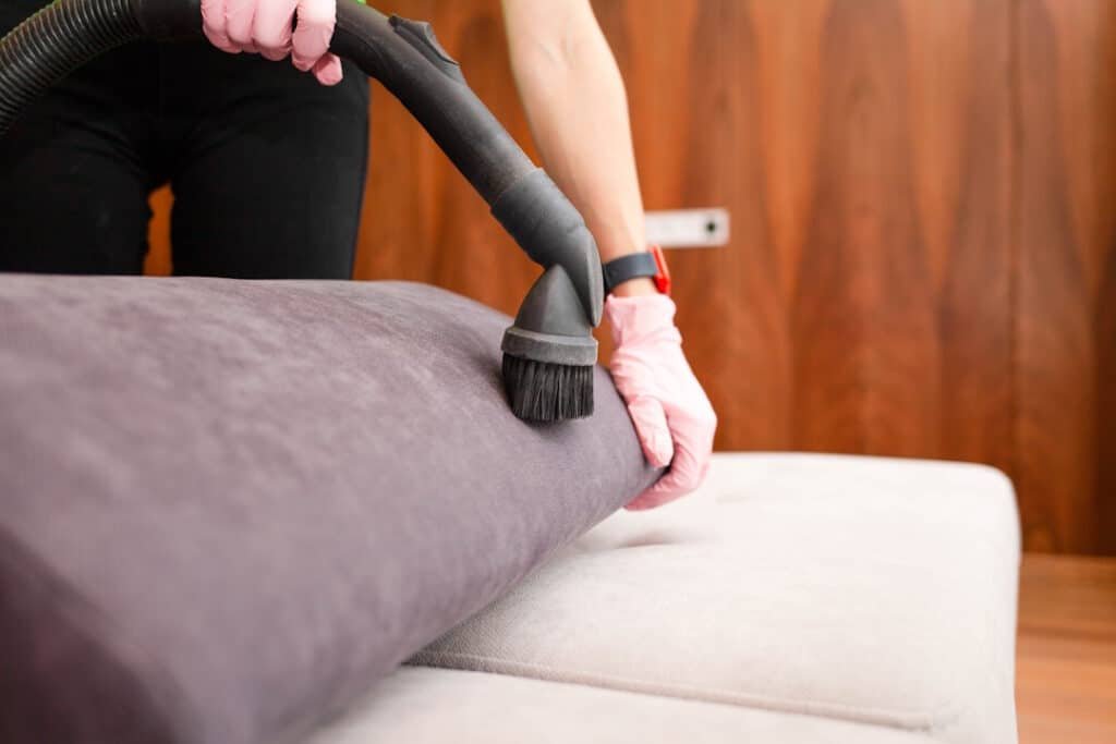 chore home concept, woman's hand in gloves gesture using a vacuum cleaner.