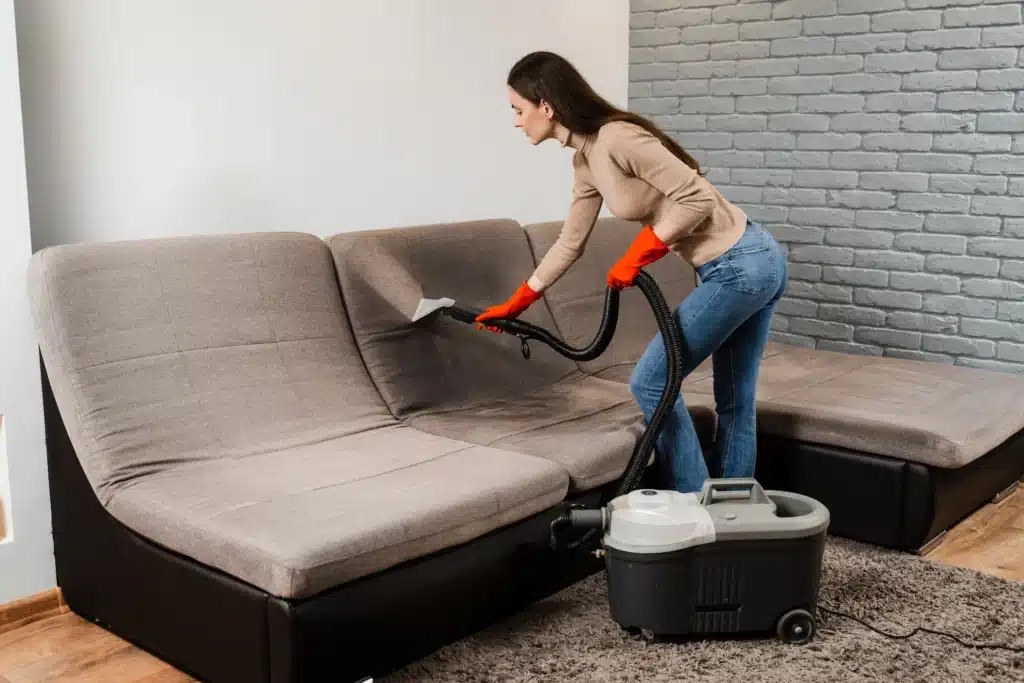 woman cleaning sofa with vacuum cleaner indoors 2026 04 05 00 02 09 utc