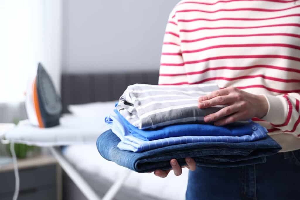 woman holding a stack of freshly ironed laundry at 2026 06 11 00 08 27 utc
