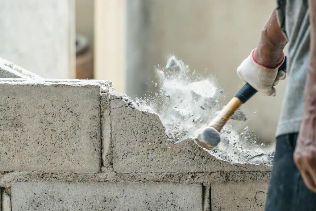 worker using sledgehammer to break concrete blocks 2026 03 24 21 34 50 utc